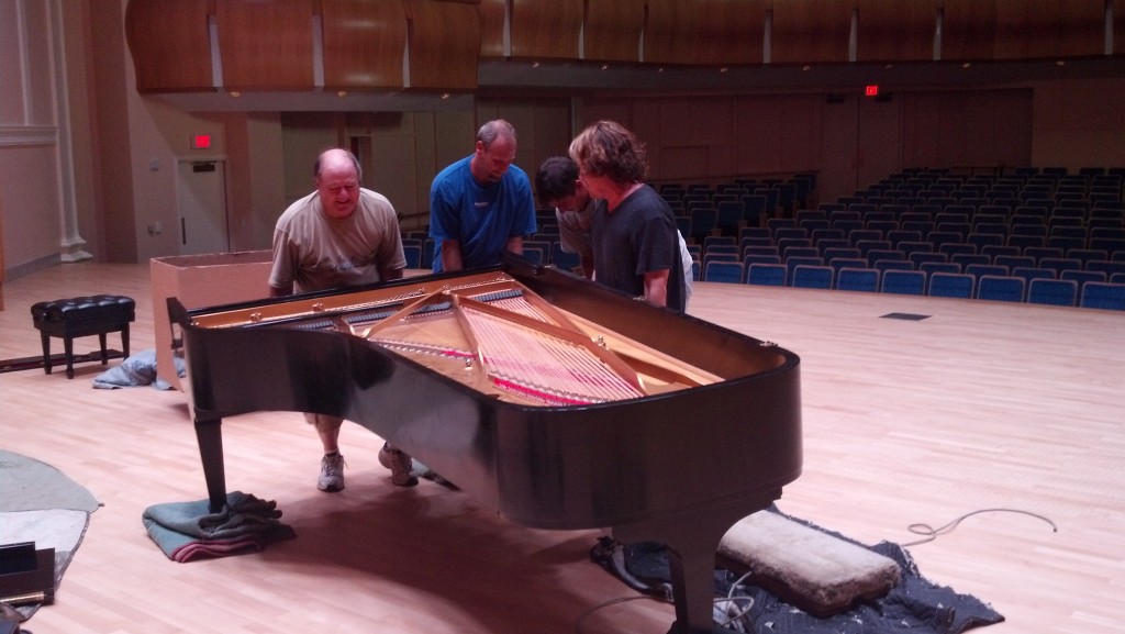 Ladd Moving team positioning a grand piano on a concert hall stage